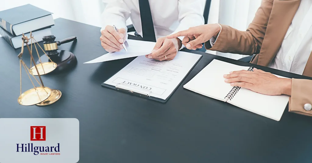 Attorney and client reviewing and signing a written contingency fee agreement at a desk, with scales of justice nearby