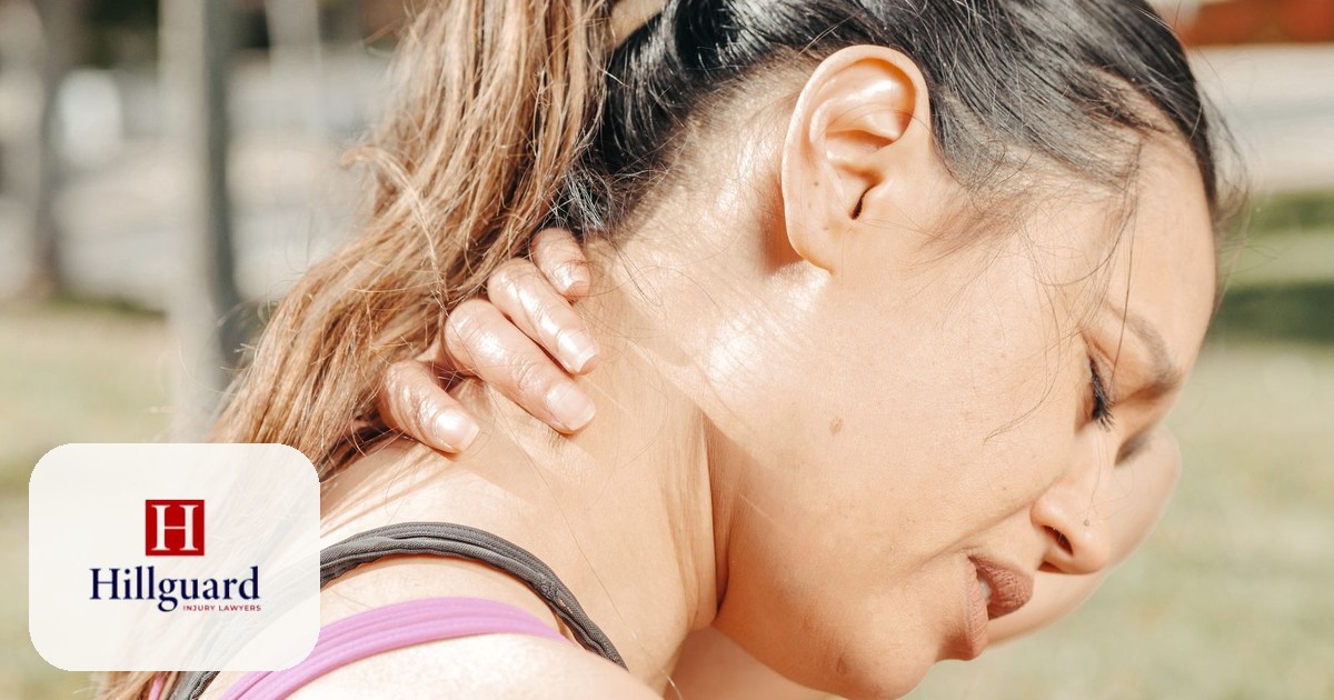 Person holding their neck in pain from whiplash after a rear-end car crash