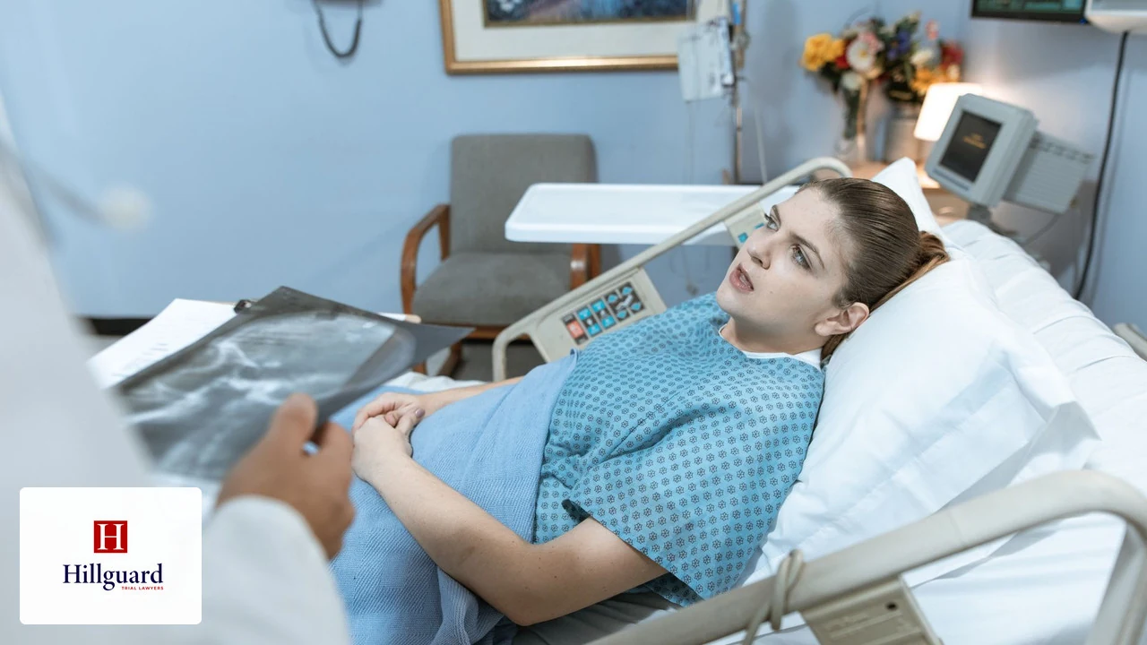 Patient in a hospital bed while a doctor reviews an X-ray of her injuries